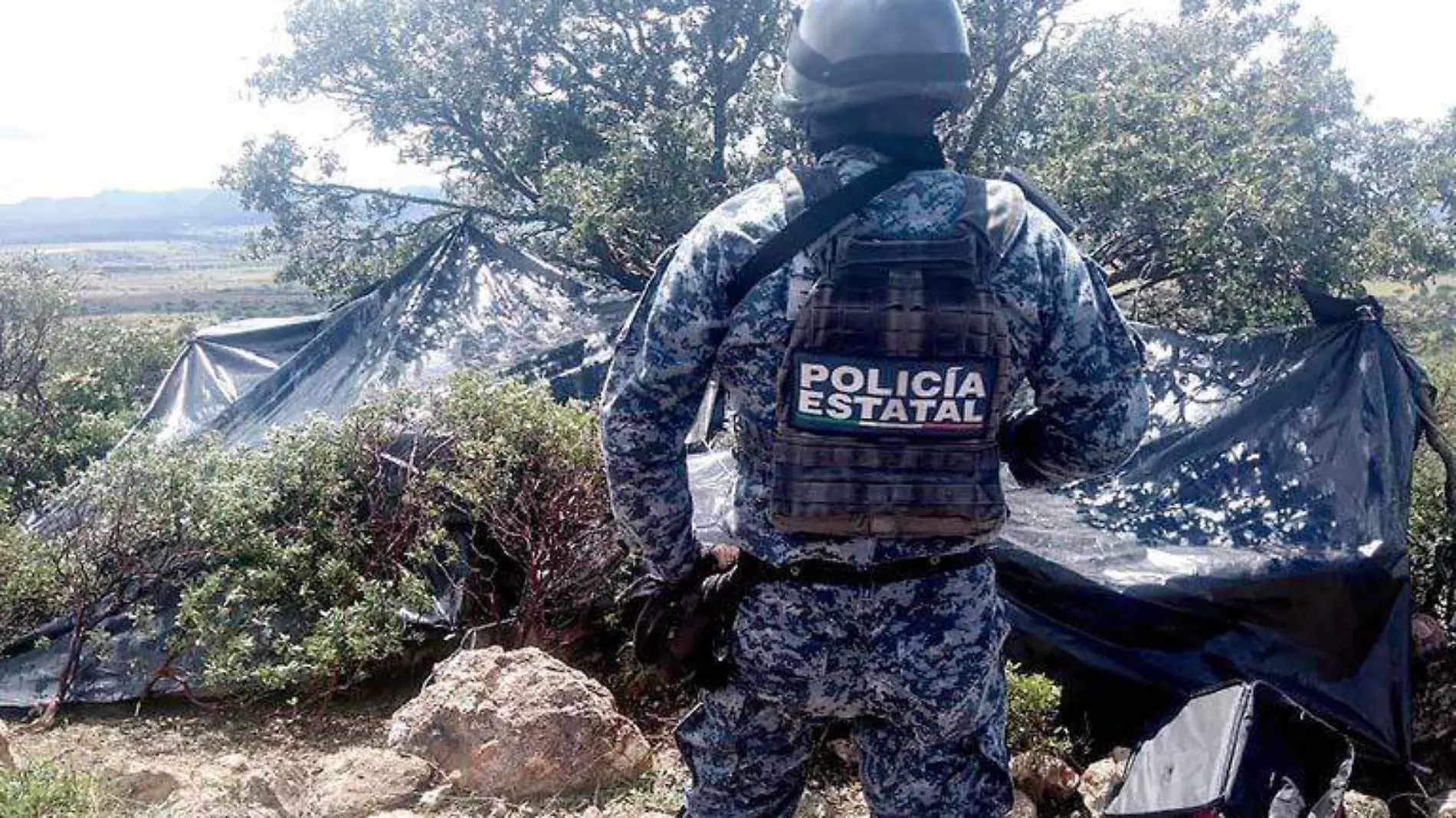 Elemento de la Policía Estatal vigilando el área donde fueron localizados los campamentos